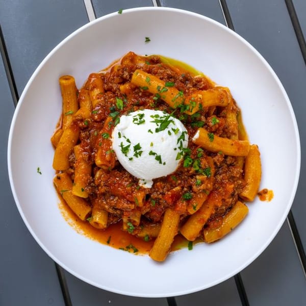 Fratelli By Jholano's rigatoni pasta with rich bolognese sauce, topped with a dollop of fresh ricotta.